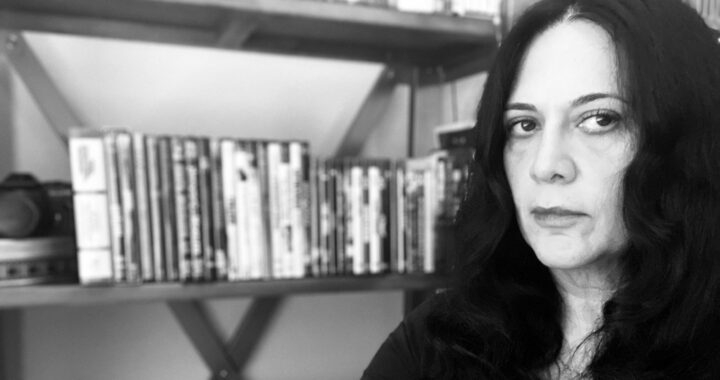 Roudi Boroumand in front of a bookshelf