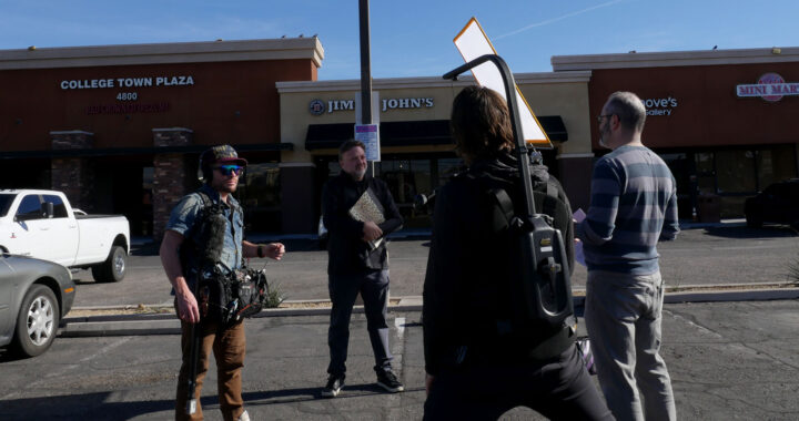Four people filming an interview for a documentary outside of a shopping center